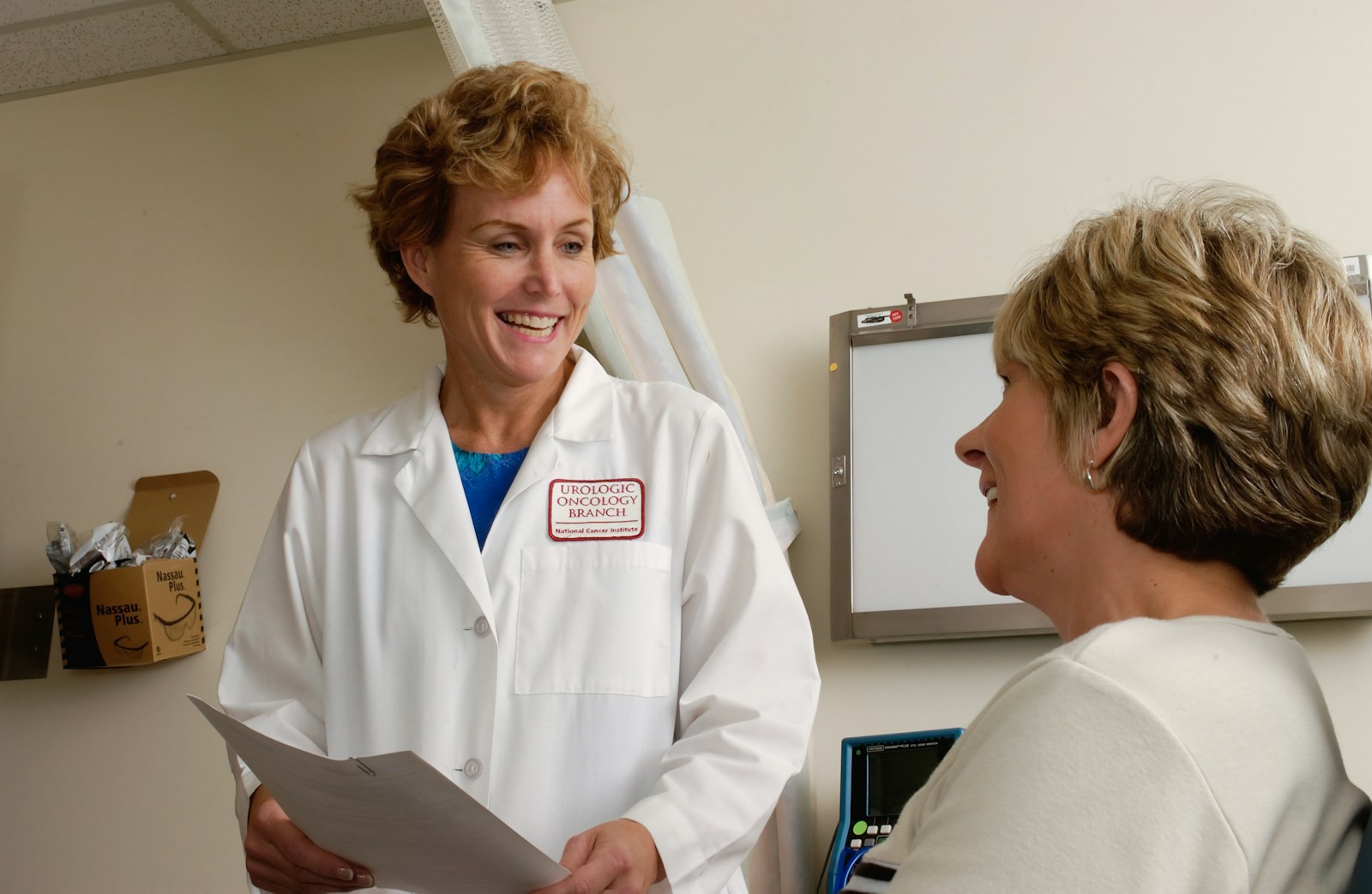 woman in white scrub suit holding gray laptop computer, health